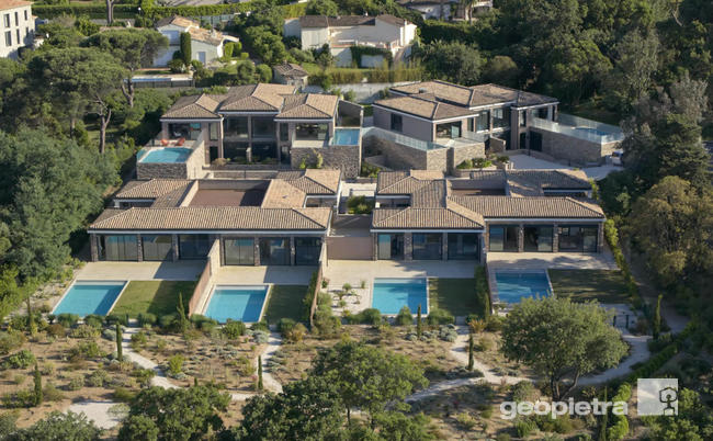 Aerial view of a luxury villa complex in Saint Tropez, featuring pools and Geopietra manufactured stone cladding